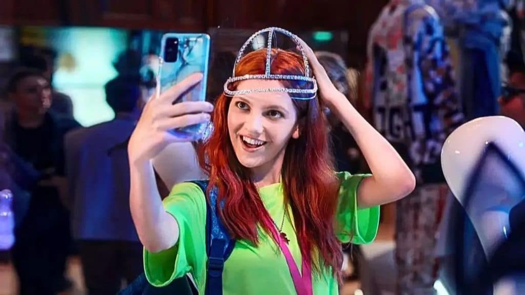 A girl posing for a selfie in a hat in Geek Girl