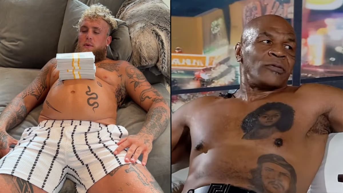 Jake Paul laying down with money on his chest next to mike tyson also laying down topless