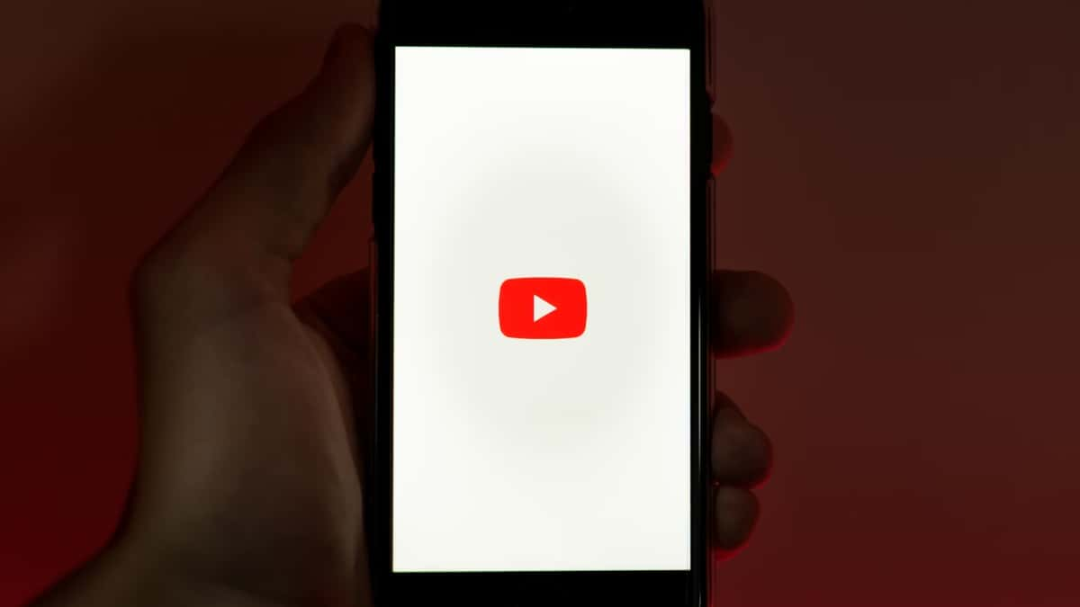 Hand holding a phone with the YouTube app up