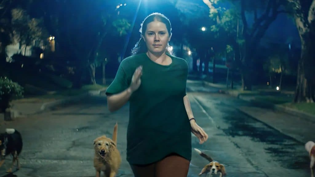 Amy Adams running with dogs in Nightbitch.