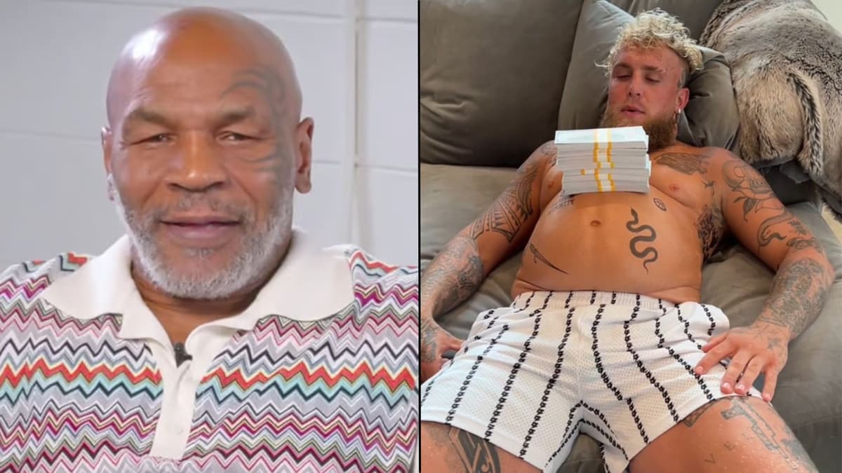 Mike Tyson sitting up with Jake Paul laying down with money on stomach