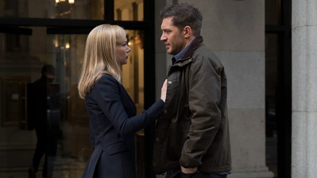 Michelle Williams with her hands on Tom Hardy's chest in Venom.