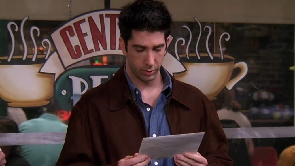 Ross holding Rachel's wedding invitation in The One with the Invitation