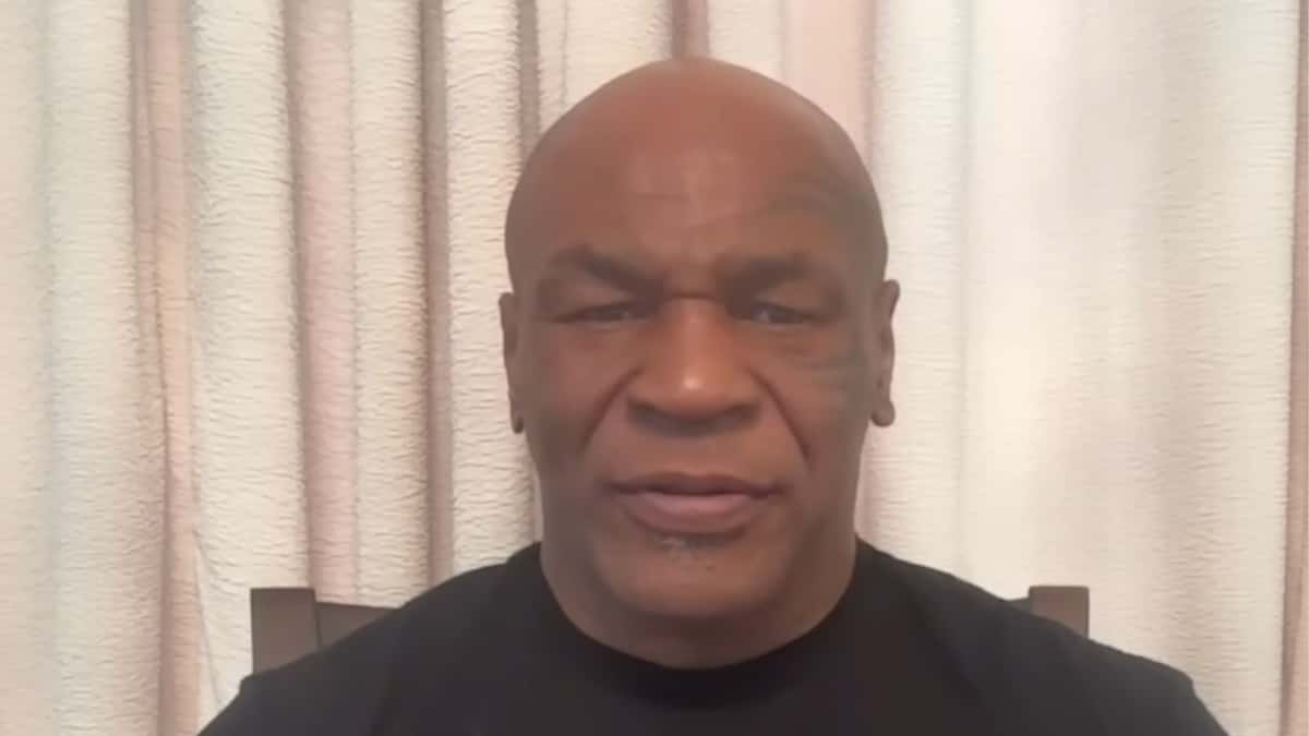 Mike Tyson in black tyson t shirt talking to camera