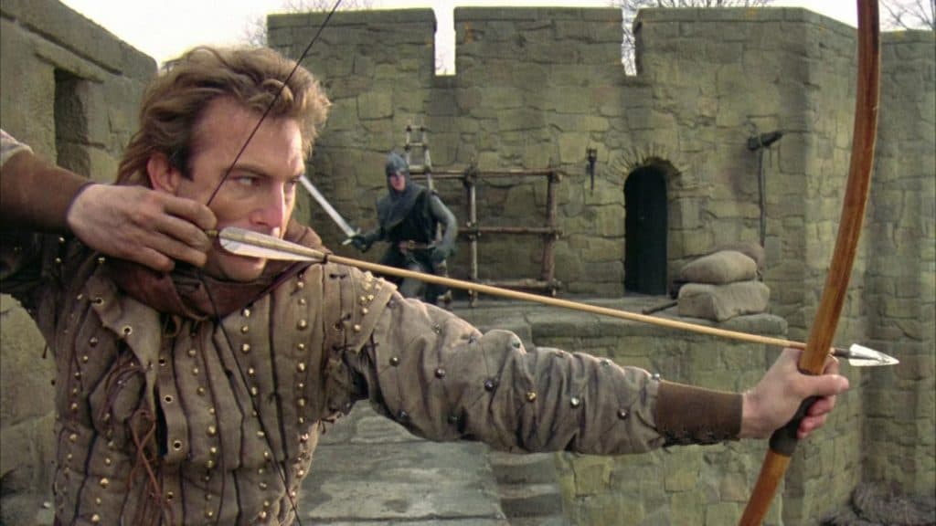 Kevin Costner as Robin Hood, holding a bow and arrow