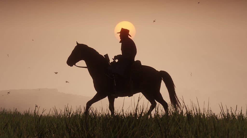 A sunset in RDR2 with a silhouette of Arthur Morgan riding a horse