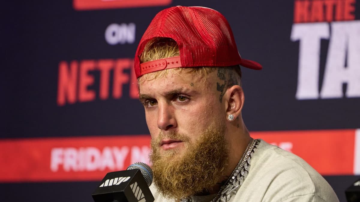 Jake Paul with red backwards cap talking at post-fight press conference