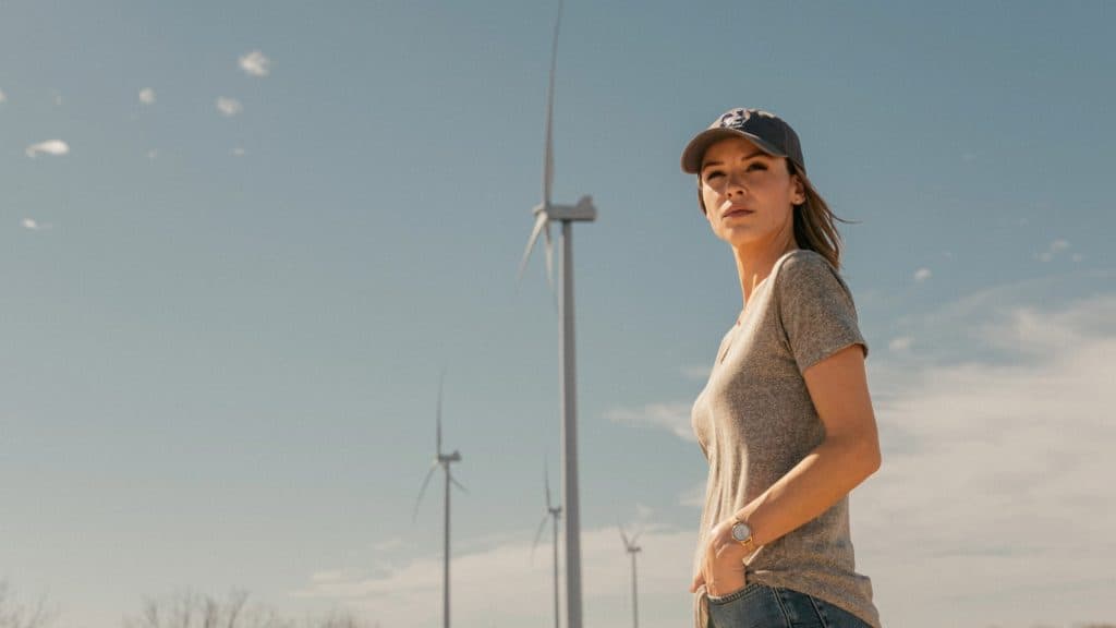 Rebecca stands under a wind turbine in Landman