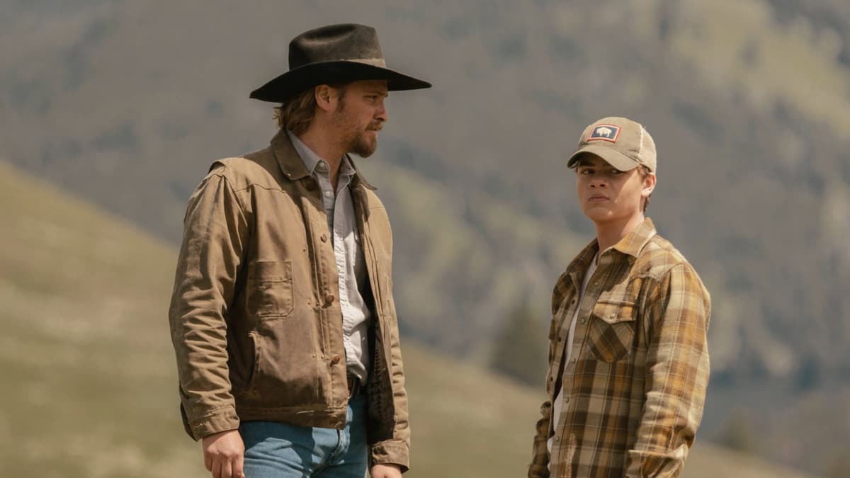 Luke Grimes as Kayce in Yellowstone, standing with Tate