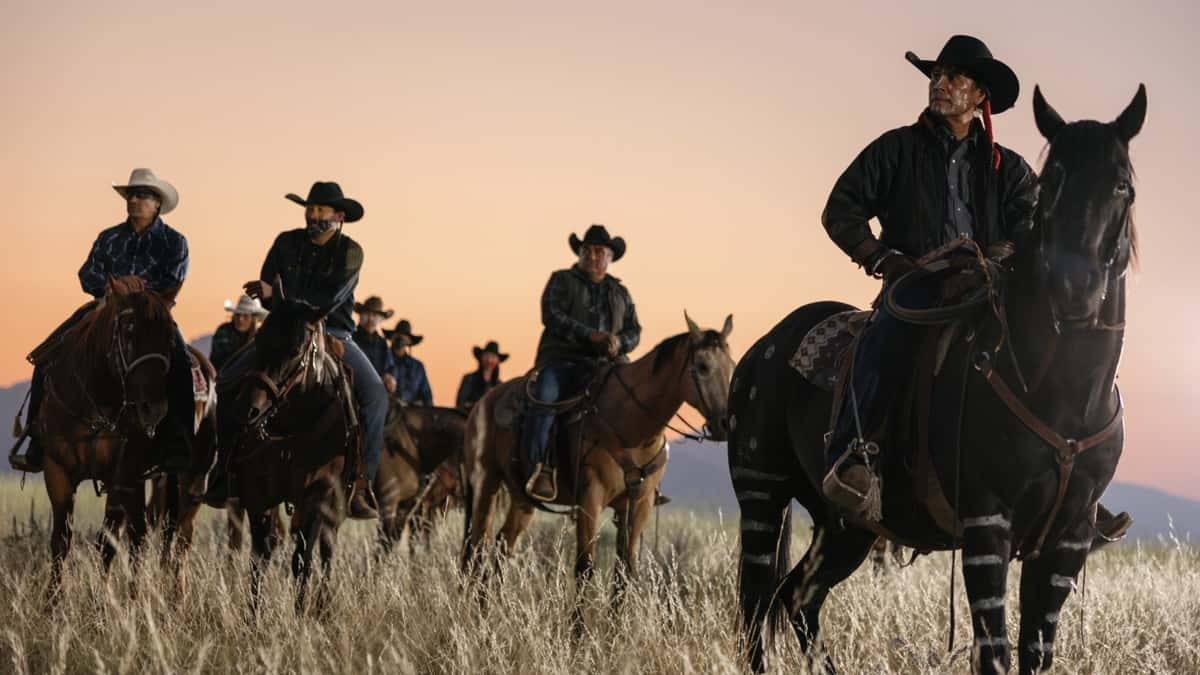 A group of men on horses against the sunrise in Yellowstone