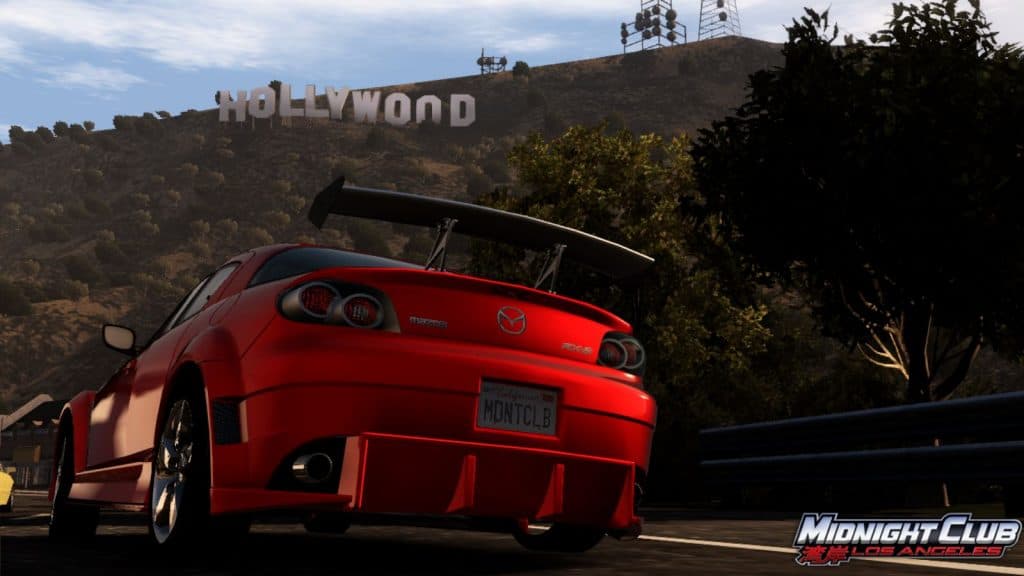 Red car parked under Hollywood sign