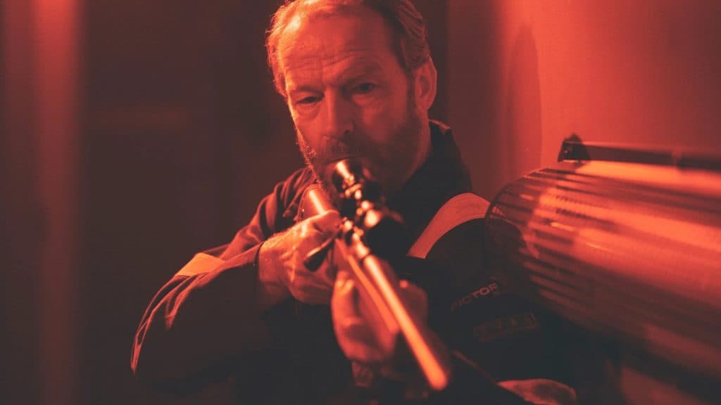 Iain Glen holding a gun in The Rig.