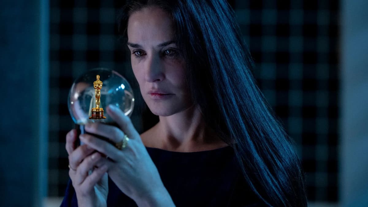 Demi Moore in The Substance looking at an Oscars statue in a snow globe