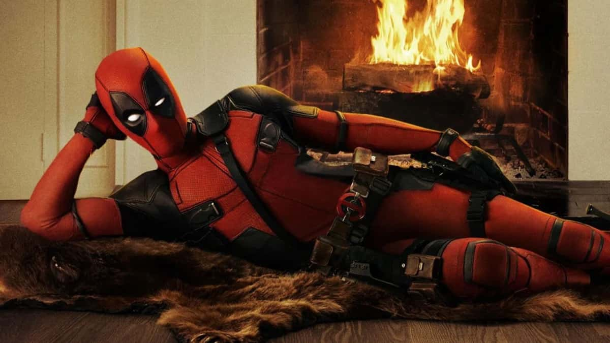 Deadpool laying on rug in front of fire