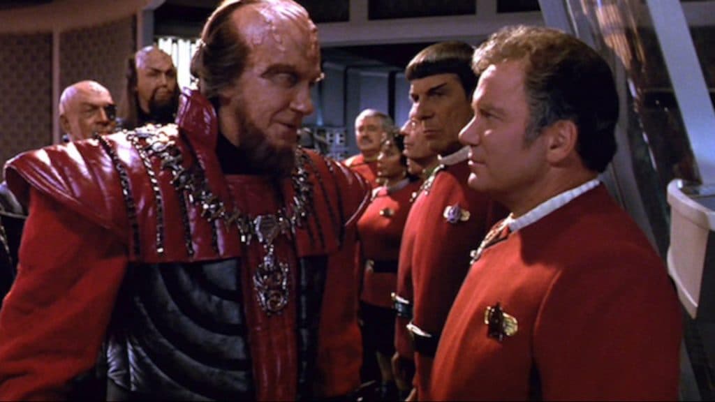 Captain Kirk welcomes a Klingon ambassador in the Enterprise tranporter room.