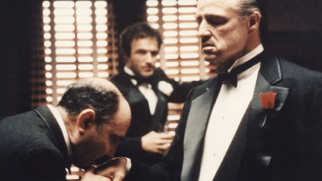 A man pays his respects to Don Corleone in The Godfather.