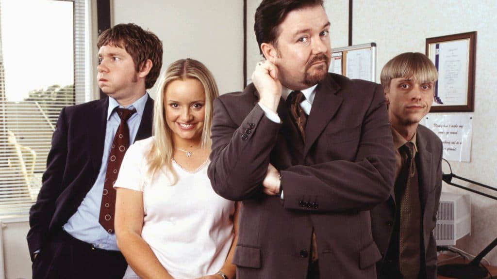 Tim, Dawn, David, and Gareth posing for the camera in The Office.