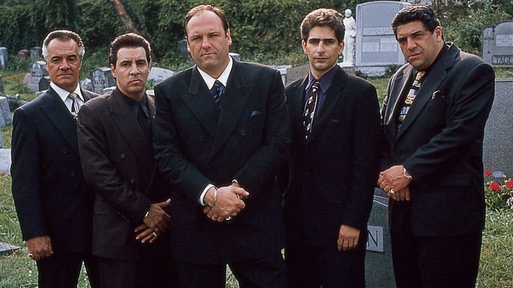 The Sopranos guys wearing suits and standing in a graveyard.