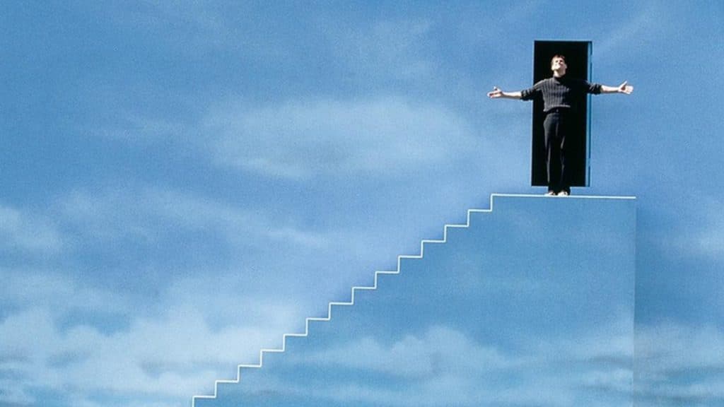 Truman stands at the top of the steps in The Truman Show