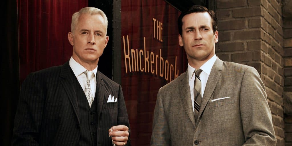 Roger Sterling and Don Draper stand outside a bar door in Mad Men