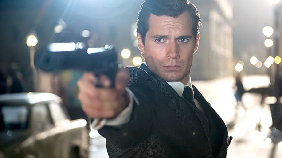 Henry Cavill pointing a gun in Man From UNKLE.